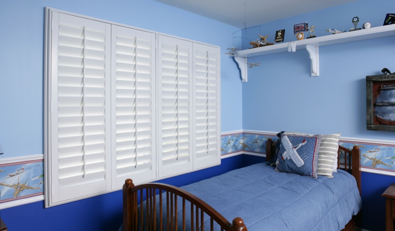 White plantation shutters in blue kids bedroom in Denver 